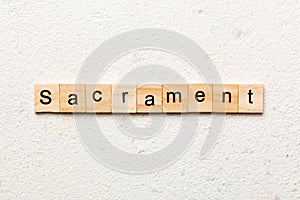 sacrament word written on wood block. sacrament text on table, concept
