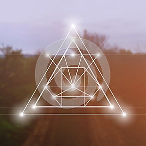 Sacred geometry symbol on blurred photo background. Mathematics and spirituality in nature.