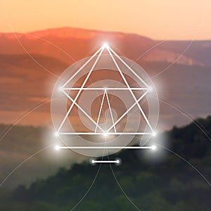 Sacred geometry symbol on blurred photo background. Mathematics and spirituality in nature.