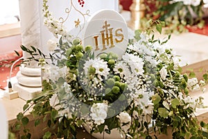 IHS Monogram Displayed in Church During First Holy Communion Ceremony photo