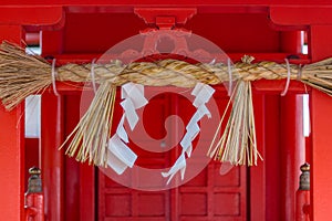 Sacred rope, or shimenawa, and shide, paper streamers, at Nomachiinari shinto shrine in Kanazawa, Japan photo