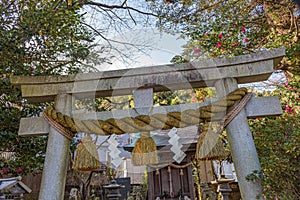 Sacred rope, or shimenawa, and streamers, or shide, on torii gate to small local shinto shrine, Kanazawa, Japan