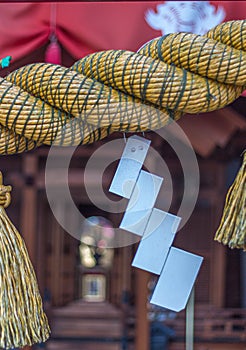 Sacred rope, or shimenawa, and zigzag streamer, or shide, on red vermillion torii gate to local shinto shrine, Kanazawa,