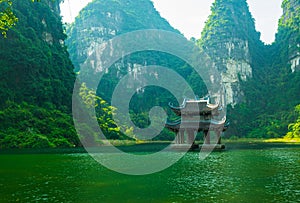 Sacred temple in the middle of the river, surrounding by limestone cliff