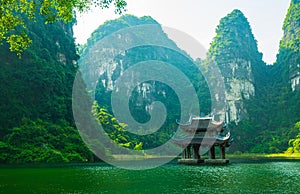 Sacred temple in the middle of the river, surrounding by limestone cliff