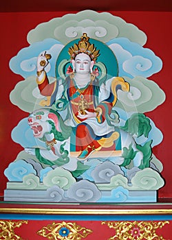 Sacred wall paintings with a Tibetan deity in a crown on a mythical beast belly in a monastery