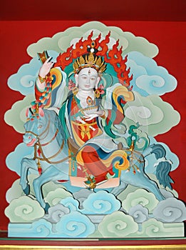 Sacred wall paintings with a Tibetan deity with three eyes on a horse in a monastery