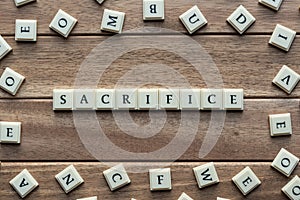 Sacrifice word cube on wood background