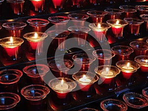 Sacrificial candles that believers light in a Catholic church in front of the altar photo