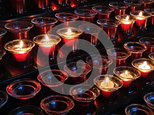 Sacrificial candles that believers light in a Catholic church in front of the altar photo