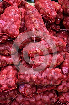 Sacs containing Large onion stacked for sale