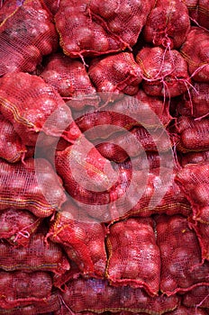 Sacs containing Large onion stacked for sale photo
