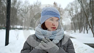 Sad adult woman walking alone on snowy day in winter closeup