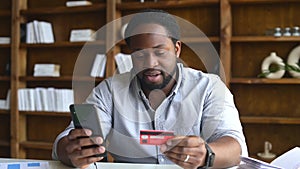 Sad African-American guy with phone and credit card