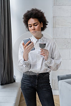 sad african american woman holding glass