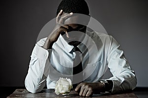 Sad African business man and rose in valentines day