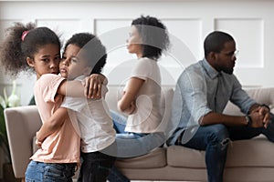 Sad african children embracing upset at parents fight at home