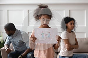 Sad african girl holding family picture upset about parents divorce