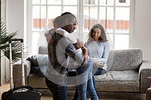 Sad african kid girl hugging dad upset by father leaving