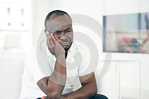 Sad african man lies on the bed