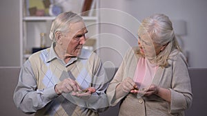 Sad aged couple counting coins, needing money for life, social insecurity