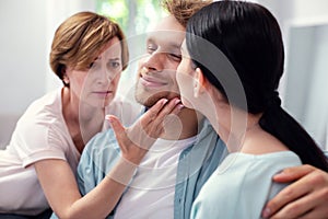 Sad aged woman touching her sons cheek