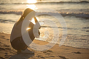 Sad and alone young woman at the beach. photo