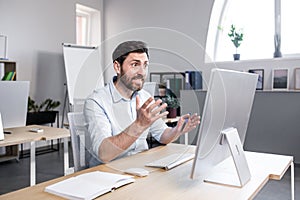 Sad and anxious man working in the office, businessman frustrated by the result of work tired and depressed looking at the monitor