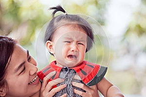 Sad asian baby girl crying and mother comforting her