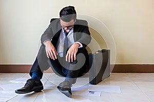 Sad Asian businessman sit on floor