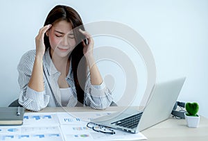 Sad Asian businesswoman employee unhappy working with bored on the laptop and chart in the office tired