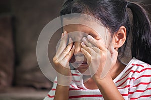 Sad asian child girl is crying and rubbing her eyes