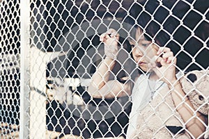 Sad Asian girl child alone in cage was imprisoned make no freedom or lack of freedom