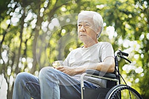 Sad asian senior man sitting in wheelchair