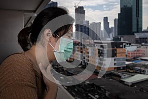 Sad asian woman in a face mask suffer from cough because of air pollution,girl wearing medical protective mask on her face in the