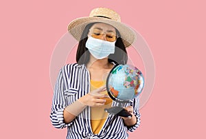 Sad Asian Woman Holding Globe, Wearing Protective Face Mask