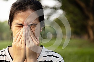 Sad asian young woman holding her nose with closed eyes while paranasal sinus pain,sinusitis symptoms or dust allergies, unhealthy