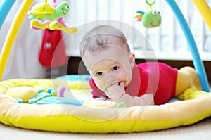 Sad baby on playmat photo