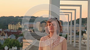 Sad beautiful stylish young woman walking on the city bridge and thinking about life