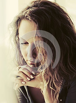 Sad beautiful woman with long curly hairs looking down