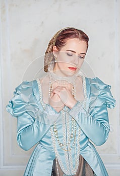 Sad Beautiful young woman in medieval style blue dress