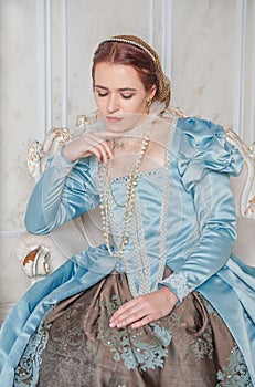 Sad Beautiful young woman in medieval style blue dress