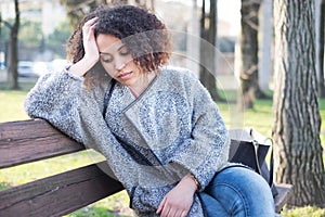 Sad black woman seated alone on a bench