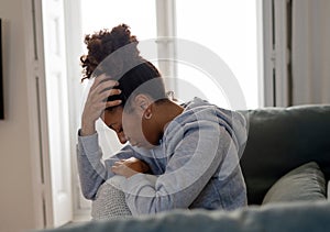 Sad black woman suffering from depression symptoms feeling distressed alone at home