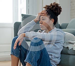 Sad black woman suffering from depression symptoms feeling distressed alone at home