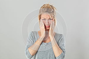 Sad blond woman crying expressing despair and distraught photo