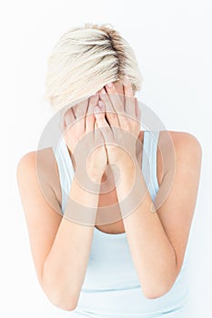 Sad blonde woman crying with head on hands