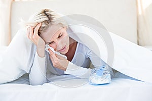 Sad blonde woman lying on the bed