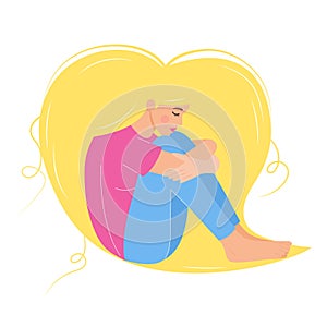 Sad blonde woman sitting and hugging her knees.