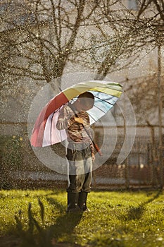 Sad boy with colorful rainbow umbrella